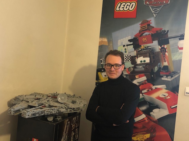 Portrait of Guillaume in front of a lego poster and a Star Wars model