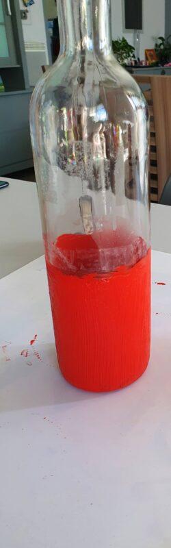 The bottle is half painted red